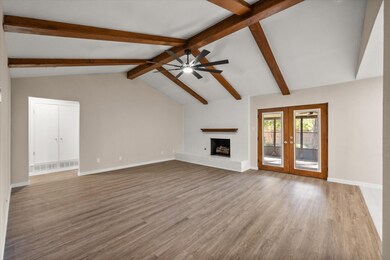 Unfurnished living room featuring light wood-style flooring, a fireplace, and french doors