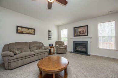 Family room has wall to wall carpet, ceiling fan, 