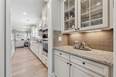 Kitchen with light stone countertops, light wood-t