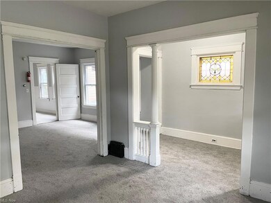 Updated interior of lower unit in duplex. New carpet and vinyl windows. View to foyer and living room.