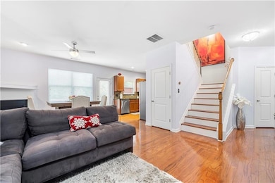 Living room with stairway, a ceiling fan, baseboar