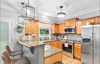 Kitchen featuring pendant lighting, sink, stone co