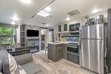 Kitchen featuring white cabinetry, a skylight, sta