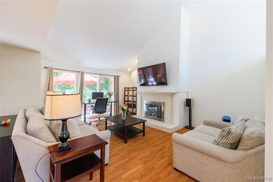 Living room featuring high vaulted ceiling, light wood-style flooring, and a fireplace