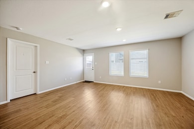Spacious Family Room with vinyl flooring, neutral walls, and recessed lighting.
