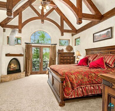 Primary bedroom featuring gas fireplace, beamed ce