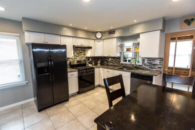 Continuation of panorama - Custom cabinets, superior appliances and contemporary tile back splash. Note window over the sink overlooking the sun porch and door to sun porch.