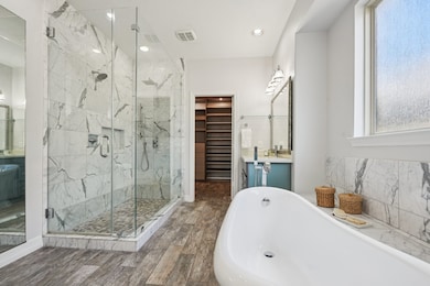 The enormous shower boasts dual shower heads, removable shower wand, and pebble-like flooring.