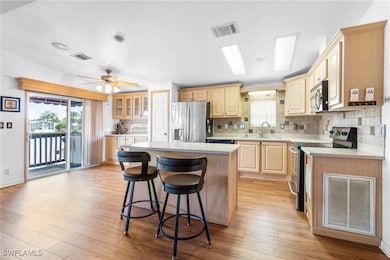 Kitchen with a kitchen island, ceiling fan, applia