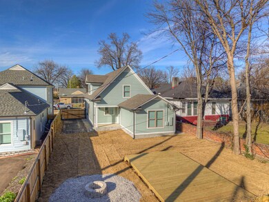 View of front facade featuring driveway, fence, an