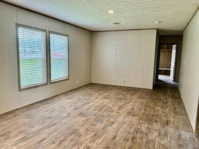 Empty room featuring a textured ceiling and hardwo