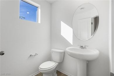 Half bath with toilet and tile patterned floors