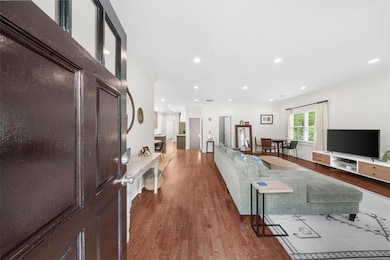 Living area featuring wood finished floors, recessed lighting, and crown molding