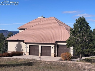 View of property exterior featuring a tiled roof, brick siding, a garage, concrete driveway, and a chimney