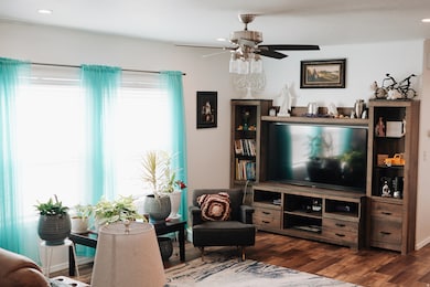 Living room featuring dark wood-style floors, recessed lighting, and ceiling fan
