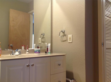 Bathroom featuring vanity and a textured wall