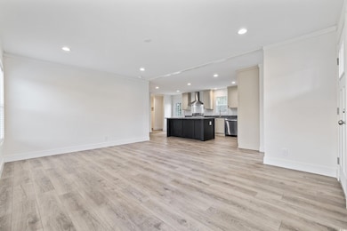 Unfurnished living room featuring ornamental molding, recessed lighting, and light wood-style floors