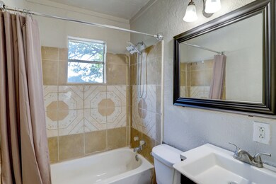 Bathroom has a tiled shower enclosure and vanity.
