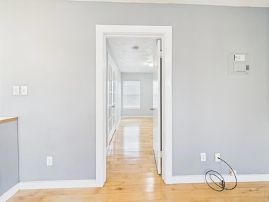 Hall featuring light wood-style flooring and base