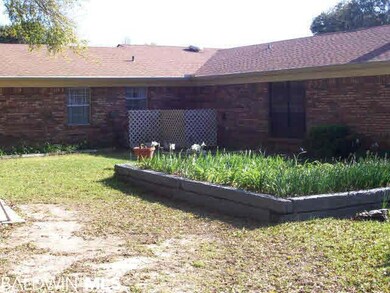 Iris bed welcomes the visitor. Fruit trees and azaleas line the back fence.