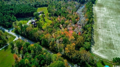 Aerial view of property's location featuring a heavily wooded area