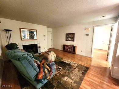 Living area with a textured ceiling, baseboards, a