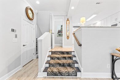 Stairway featuring ornamental molding and hardwood