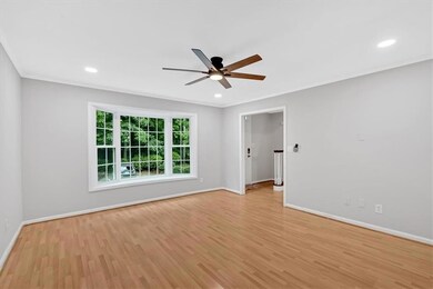 Empty room featuring a ceiling fan, light wood finished floors, baseboards, ornamental molding, and recessed lighting