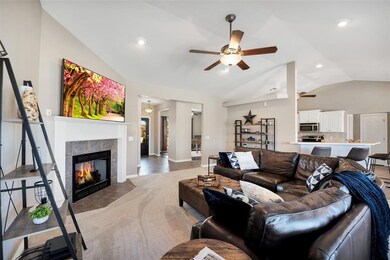 Living room with ceiling fan, vaulted ceiling, a f