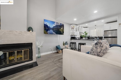 Living room featuring light wood finished floors, a tile fireplace, and recessed lighting