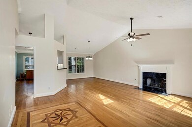 Unfurnished living room featuring a high end fireplace, baseboards, ceiling fan, light wood finished floors, and high vaulted ceiling