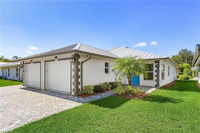 View of home's exterior with stucco siding, a yard, decorative driveway, a garage, and a metal roof