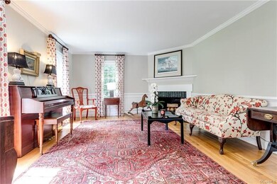 Formal living room off of foyer with fireplace, crown molding, chair rail & picture frame molding