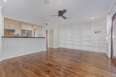 Unfurnished living room featuring dark wood finished floors, ceiling fan, recessed lighting, built in shelves, and ornamental molding