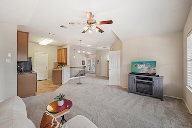 Living area featuring light carpet, ceiling fan, 