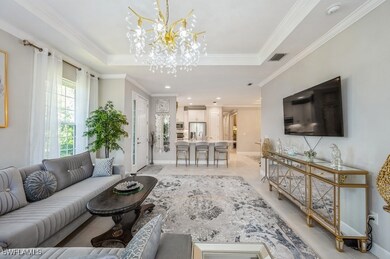 Living area with a chandelier, crown molding, a ra