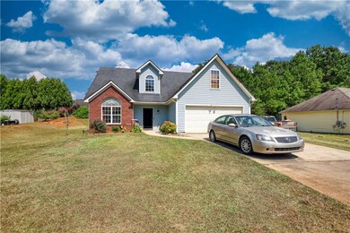 Traditional-style house with driveway, a front lawn, a garage, and brick siding