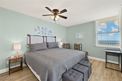 Bedroom featuring ceiling fan, baseboards, and woo