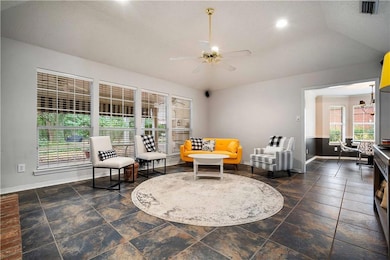 Sitting room with a ceiling fan, a textured ceiling, stone tile flooring, and recessed lighting