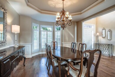 Formal dining room boasts wainscoting, trey ceiling and bay window. check out all the light. And the gorgeous floors!