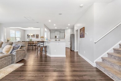 Living room featuring recessed lighting, stairs, baseboards, and dark wood finished floors