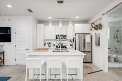 Kitchen featuring white cabinetry, light countert