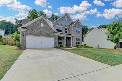 Craftsman house featuring brick siding, driveway, and a front yard