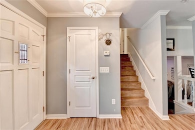 Front entrance with hardwood floors and ornamental molding