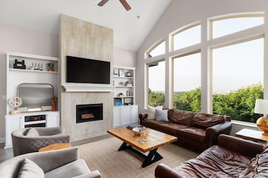Living area featuring ceiling fan, a tile firepla