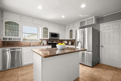Kitchen featuring dark stone counters, decorative