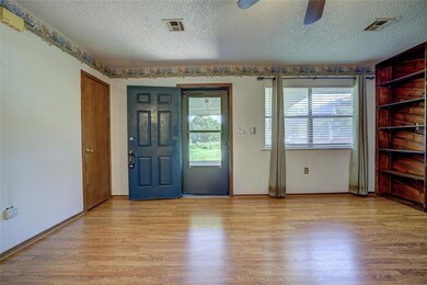 Entryway with healthy amount of natural light, a textured ceiling, light wood-style floors, a ceiling fan, and baseboards