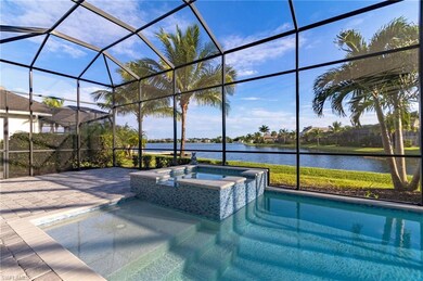 View of swimming pool featuring an in ground hot tub, a water view, and glass enclosure