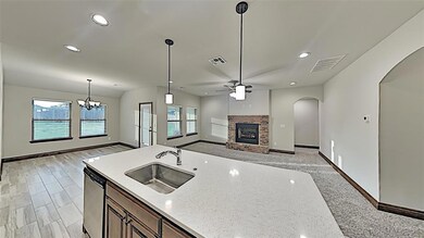 Kitchen with a sink, a fireplace, arched walkways,