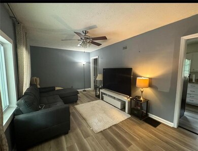 Living room with a textured ceiling, ceiling fan, 